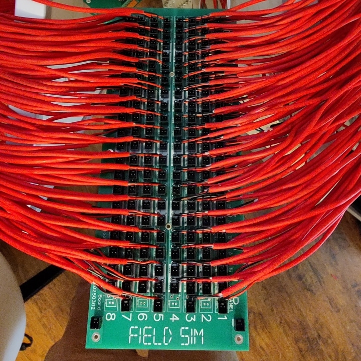 The Field Sim FS-24-TBS-JB jumper board, which is a component of the FS-24-TBS Troubleshooting Station. It has 21 columns and 8 rows of wires that terminate at header pins for jumpers to go between circuits. By adjusting the jumper configuration, the instructor can introduce various faults to one of the 4 circuits.